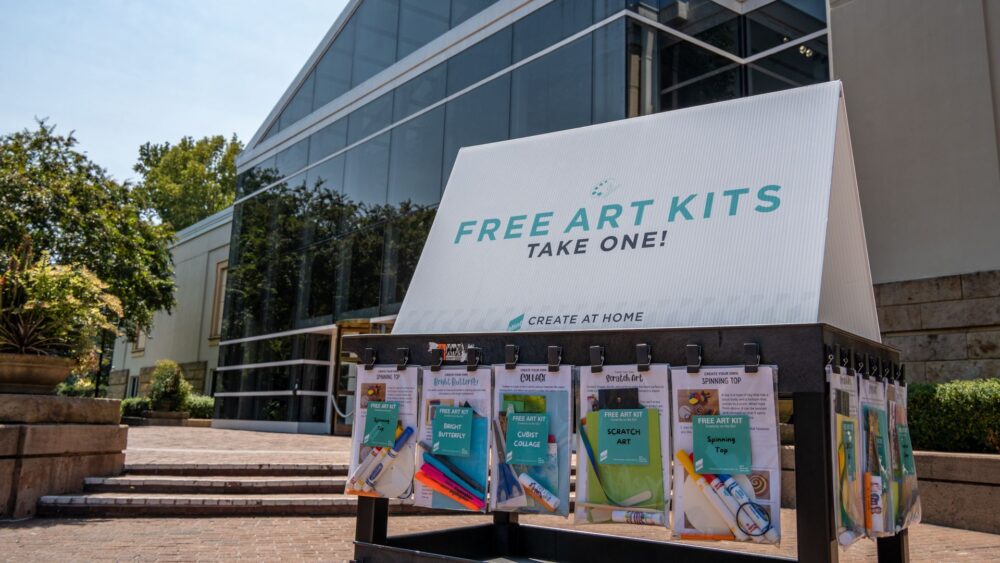 Cart with Free Art Kits in front of Mint Museum Randolph building.