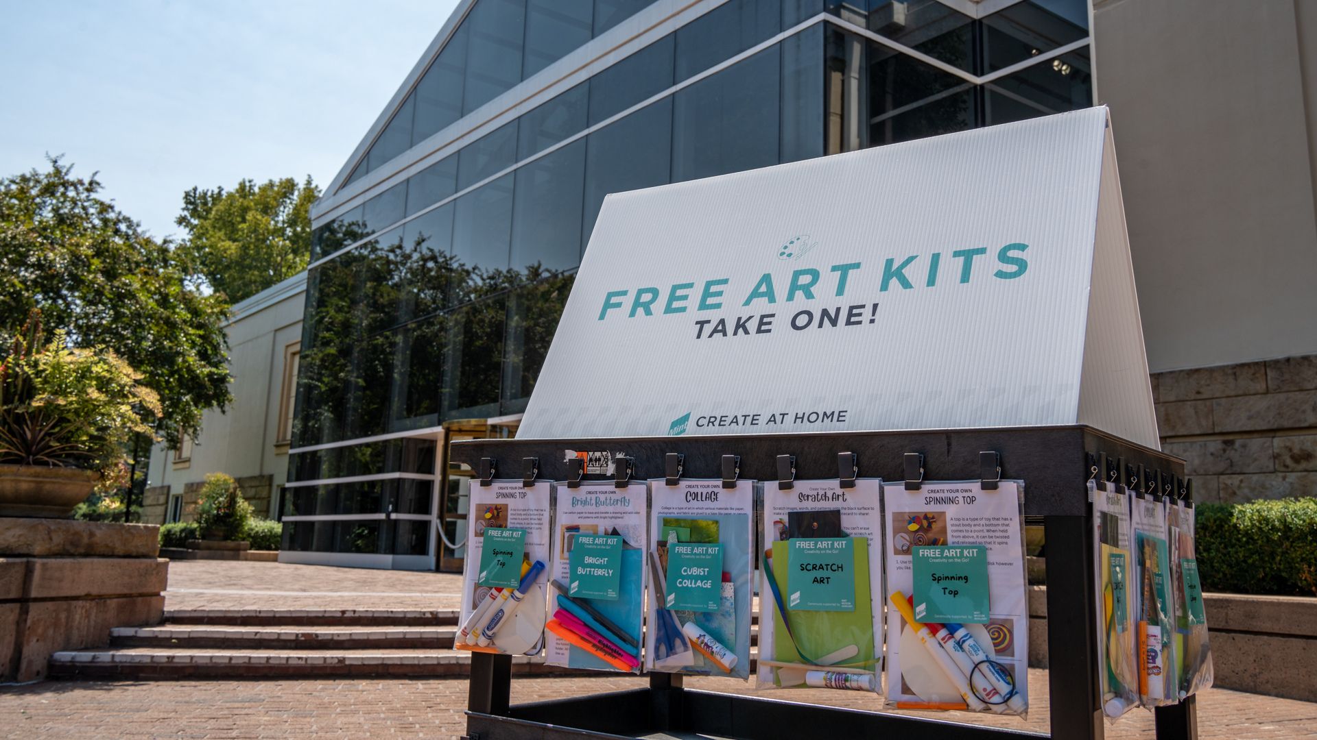 Cart with Free Art Kits in front of Mint Museum Randolph building.