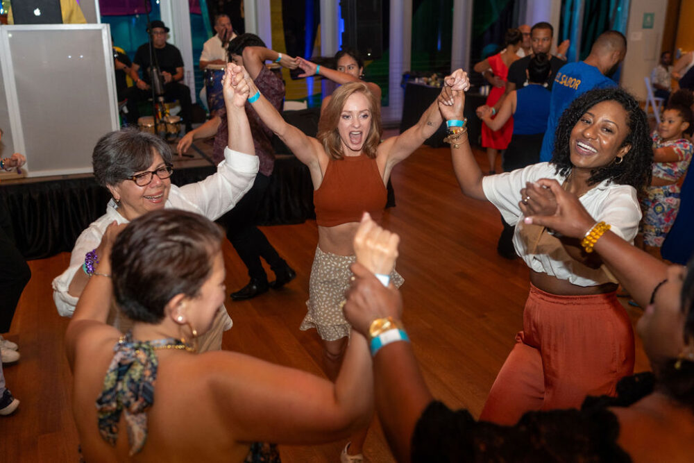 Group of people holding hands and dancing at Mint 2 Move