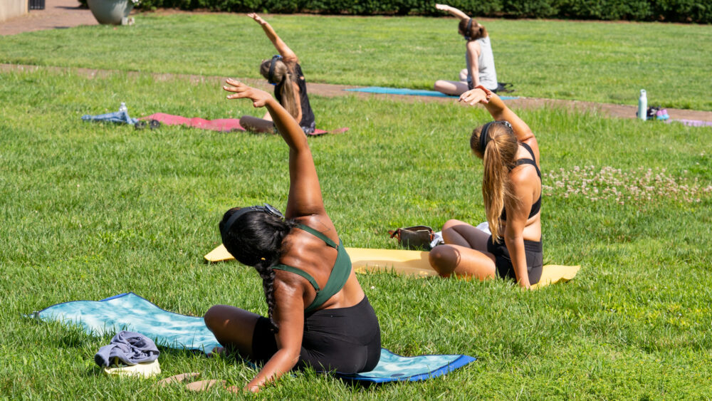 Group of people stretching on the lawn in front of Mint Museum Randolph