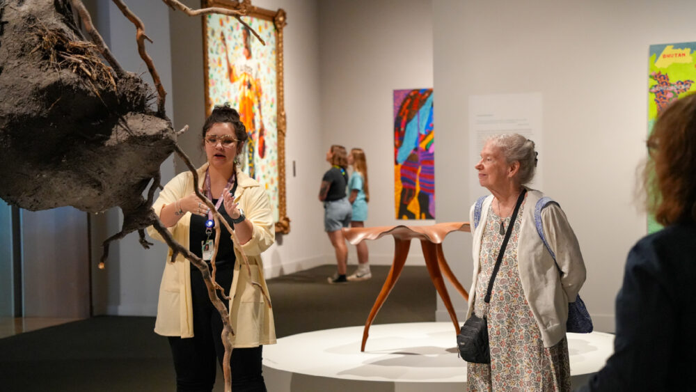 Gallery guide talking in front of sculpture