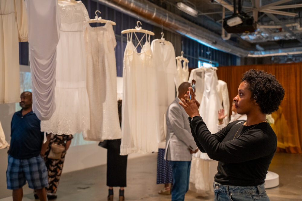 Person taking photo of hanging dresses with their phone