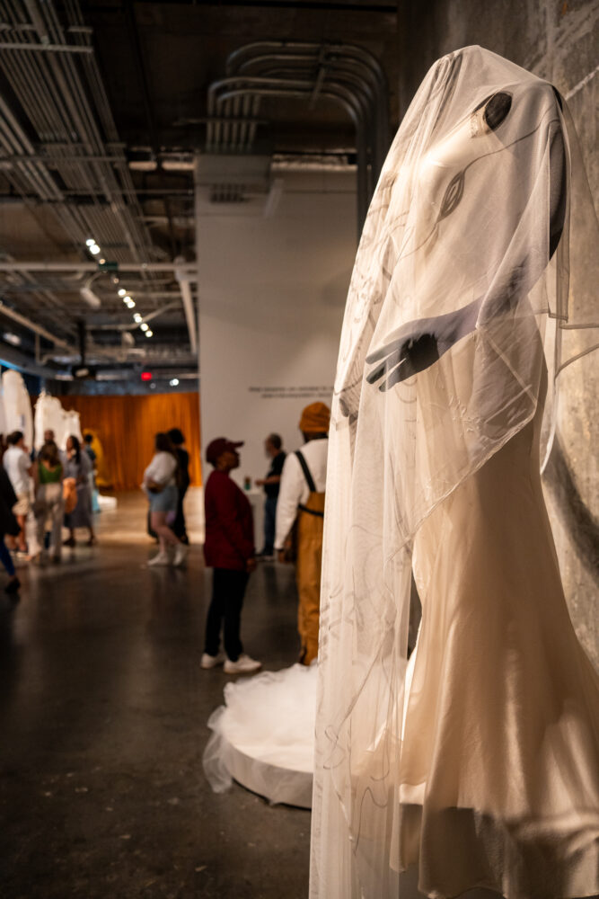 Wedding dress with people walking behind it