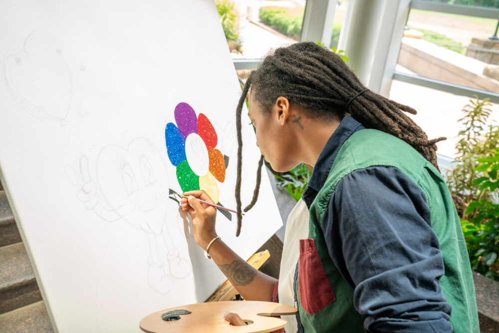 Artist painting on canvas during Party in the Park